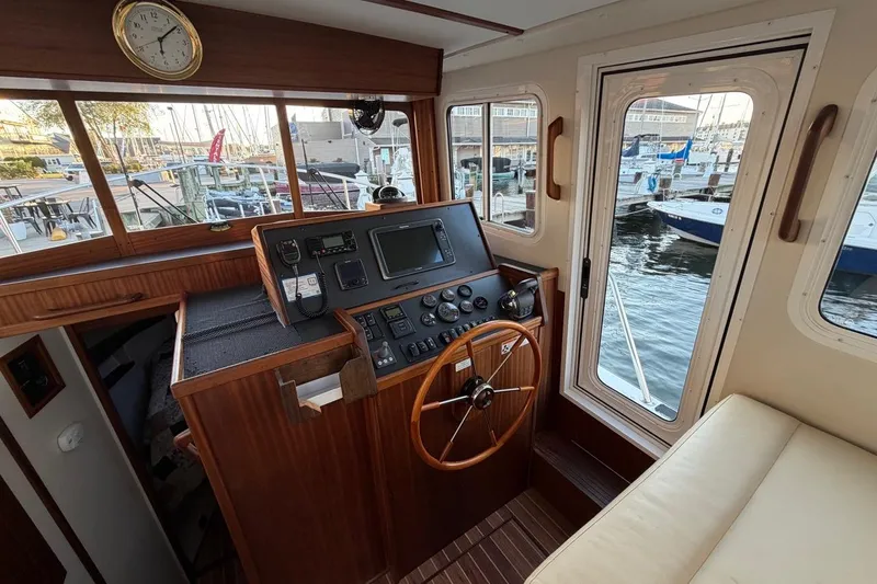 Blue Heron Yacht Photos Pics Interior helm of 2015 Nordic Tug 34 with wooden steering wheel and navigation equipment.