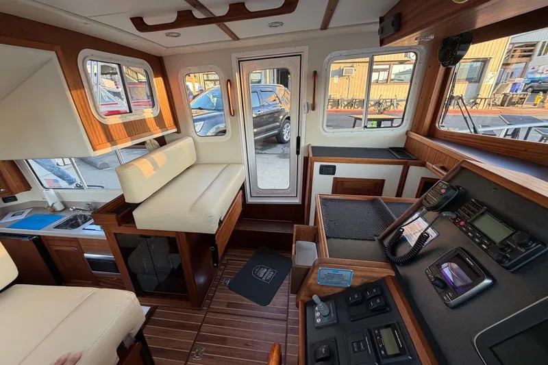 Blue Heron Yacht Photos Pics Interior of 2015 Nordic Tug 34, featuring helm, seating, and navigation equipment.