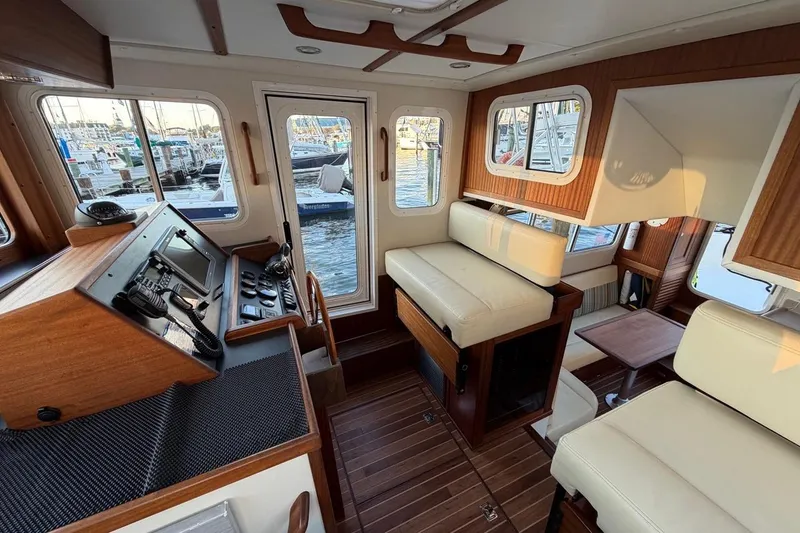Blue Heron Yacht Photos Pics Interior of a 2015 Nordic Tug 34, featuring a cozy seating area and navigation controls.