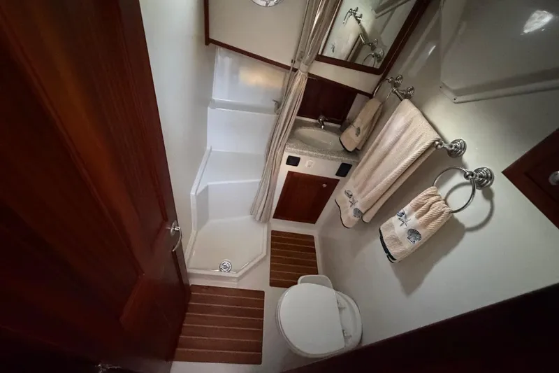 Blue Heron Yacht Photos Pics 2015 Nordic Tug 34 bathroom with shower, sink, and wooden accents.