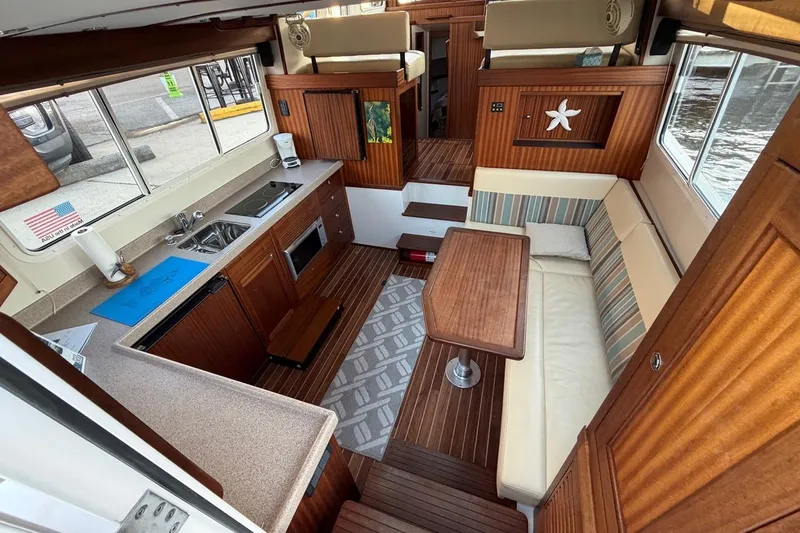 Blue Heron Yacht Photos Pics Interior of 2015 Nordic Tug 34, featuring a cozy dining area and compact kitchen.