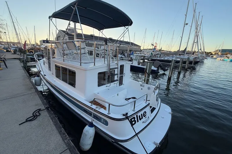 Blue Heron Yacht Photos Pics 2015 Nordic Tug 34 docked at marina, featuring spacious deck and canopy.