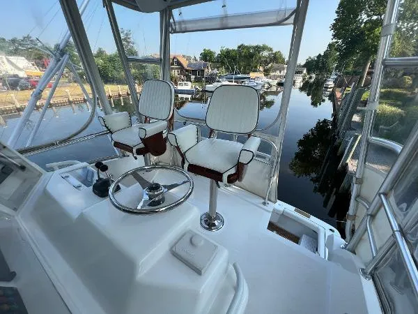  Yacht Photos Pics 2001 Bertram 39 Convertible yacht helm with dual captain chairs, overlooking a serene marina.