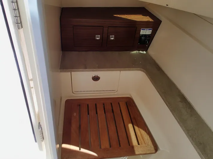 Born Free Yacht Photos Pics Interior cabin of 2017 Boston Whaler 320 Vantage with wooden flooring and storage compartments.