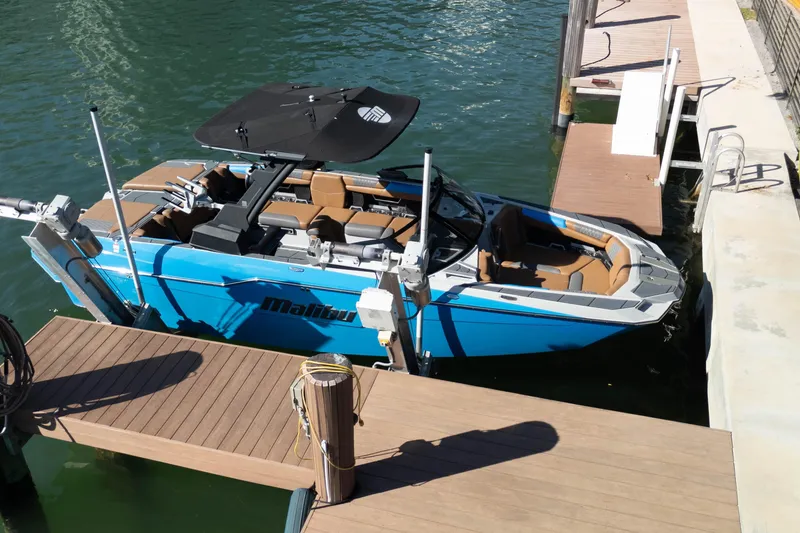  Yacht Photos Pics 2020 Malibu M240 boat docked, featuring sleek design and blue exterior.