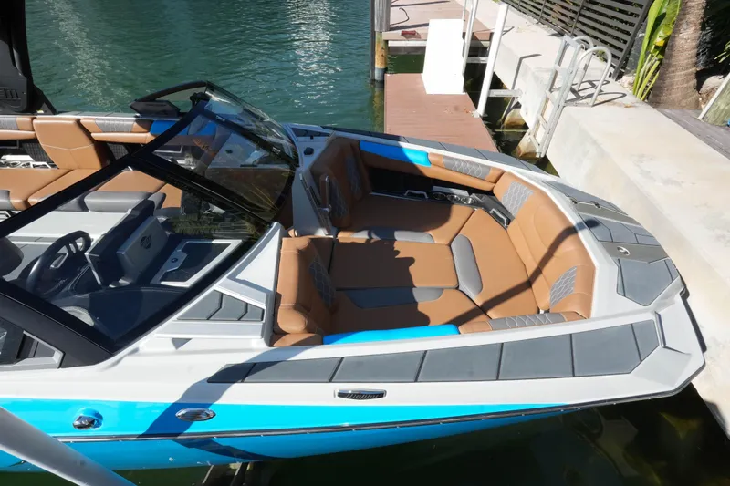  Yacht Photos Pics 2020 Malibu M240 boat with tan and gray interior docked by the water.