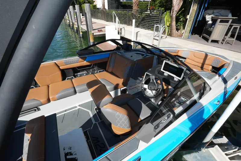  Yacht Photos Pics 2020 Malibu M240 boat interior with brown and gray seating, modern dashboard, and steering wheel.