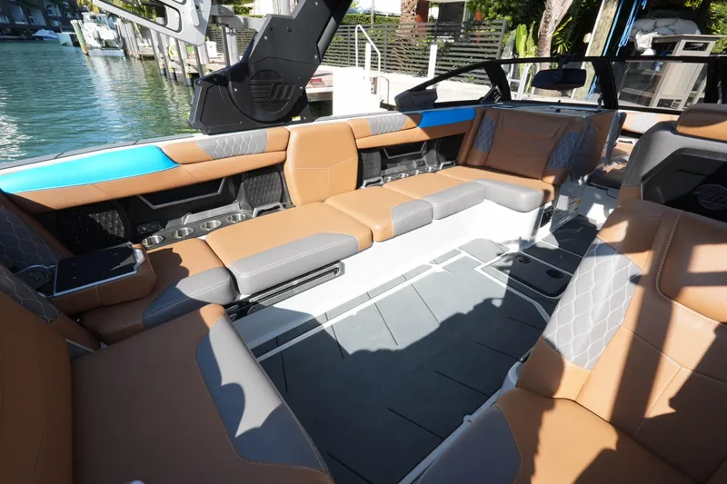  Yacht Photos Pics 2020 Malibu M240 boat interior with luxurious tan and gray seating, dockside view.