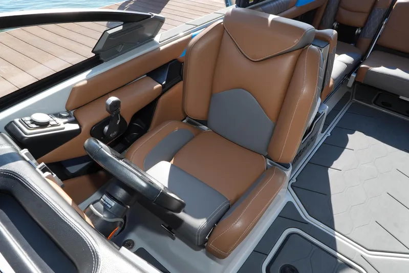  Yacht Photos Pics 2020 Malibu M240 boat interior with tan and gray seating, steering wheel, and controls.