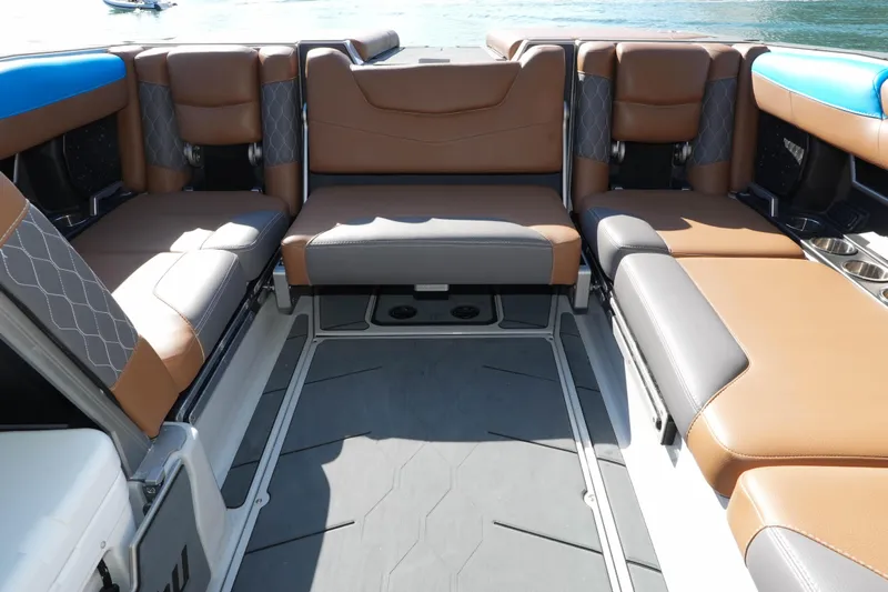  Yacht Photos Pics 2020 Malibu M240 boat interior with luxurious brown and gray seating, on a sunny day.