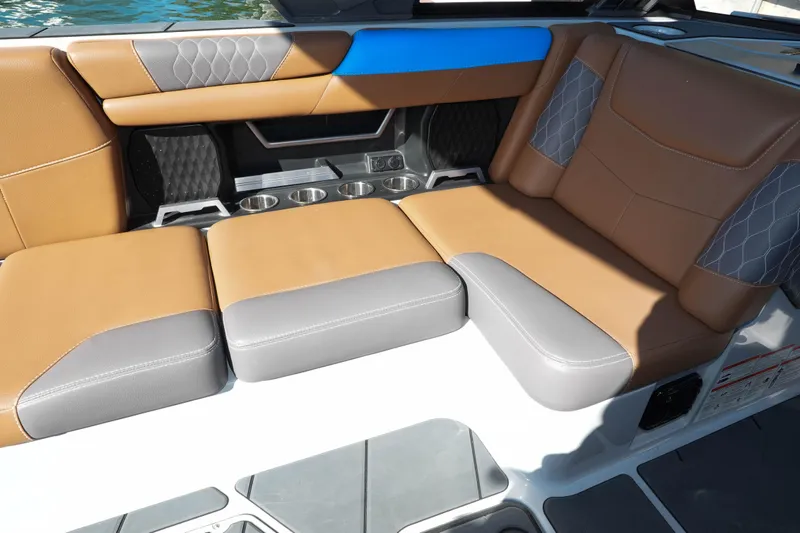  Yacht Photos Pics 2020 Malibu M240 boat interior with tan and gray seating, cup holders, and quilted accents.