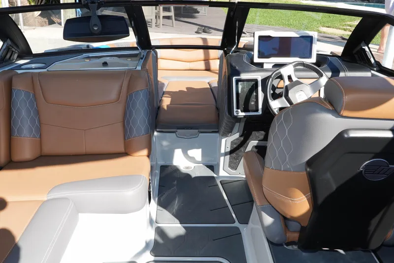  Yacht Photos Pics 2020 Malibu M240 boat interior with luxurious tan and gray seating, modern dashboard.