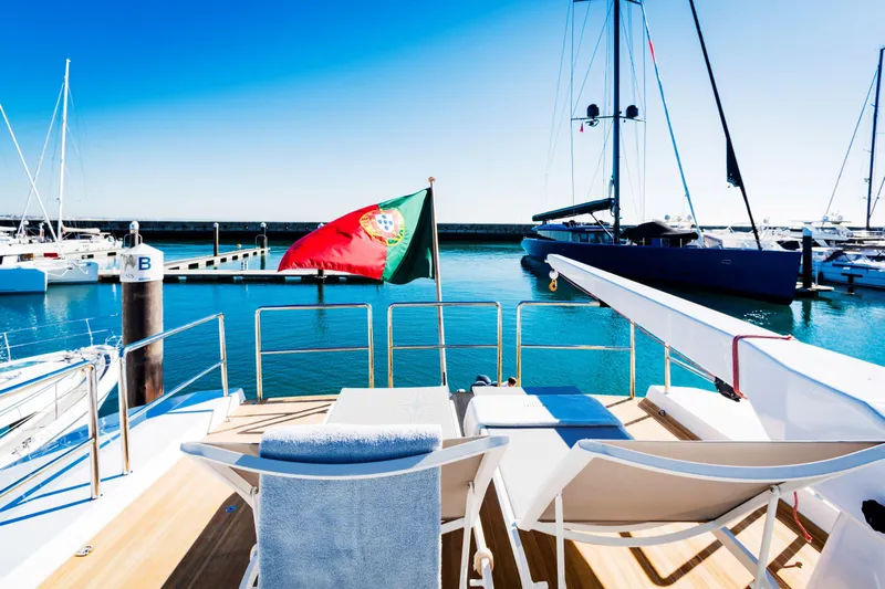  Yacht Photos Pics Versilcraft FALCON 82 yacht, 1987, docked with Portuguese flag, sunny marina view.