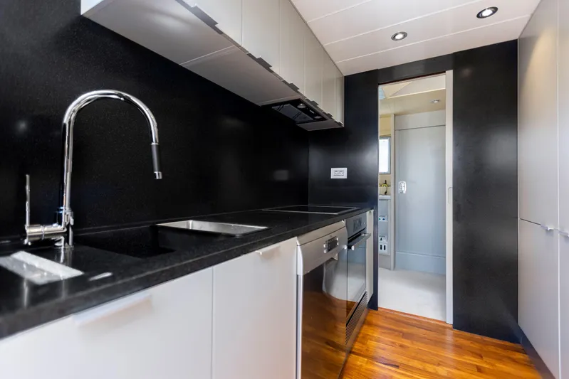  Yacht Photos Pics Modern kitchen interior on 1987 Versilcraft FALCON 82 yacht with sleek black countertops.