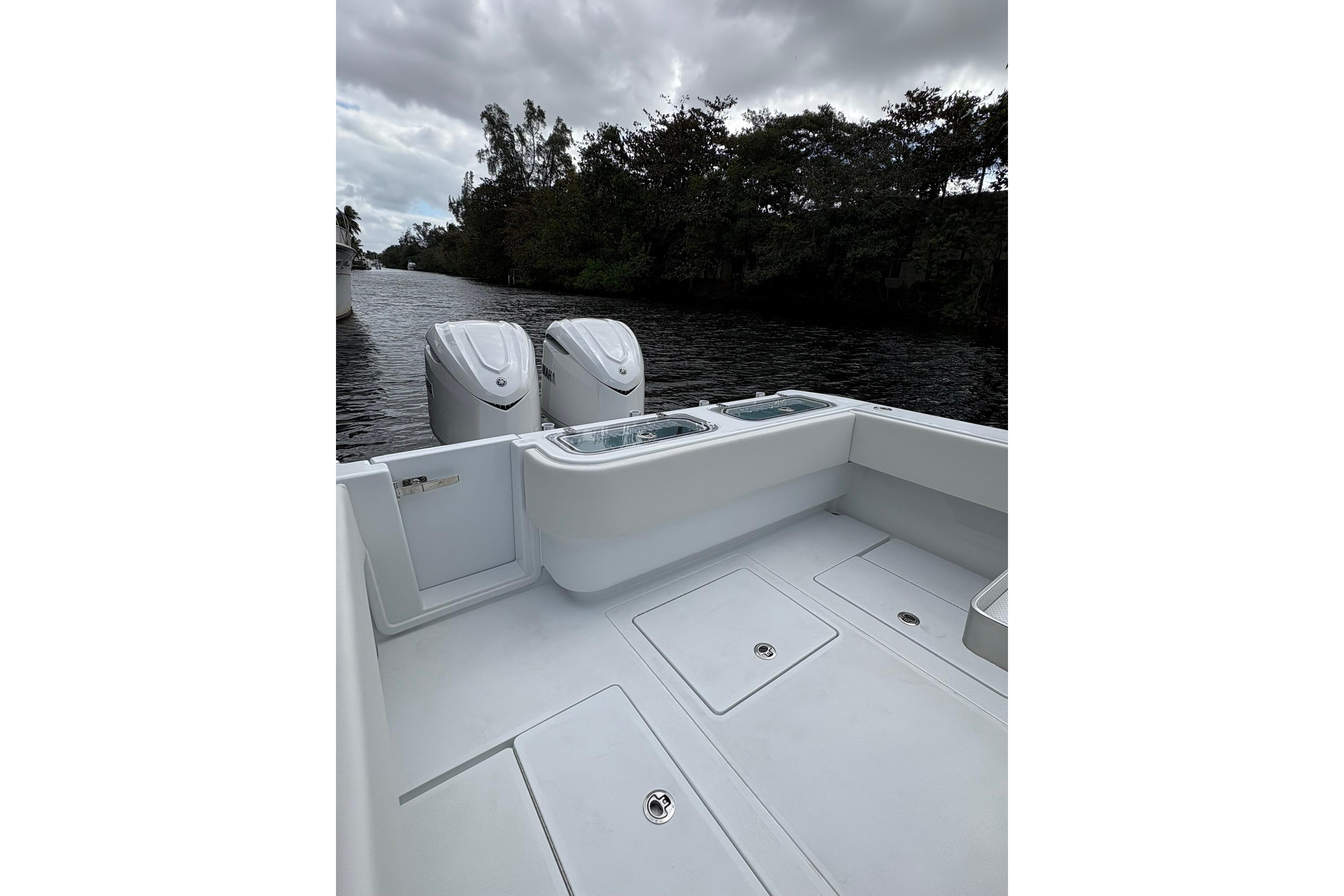 2025 Contender 32 ST boat with dual engines on a calm river.