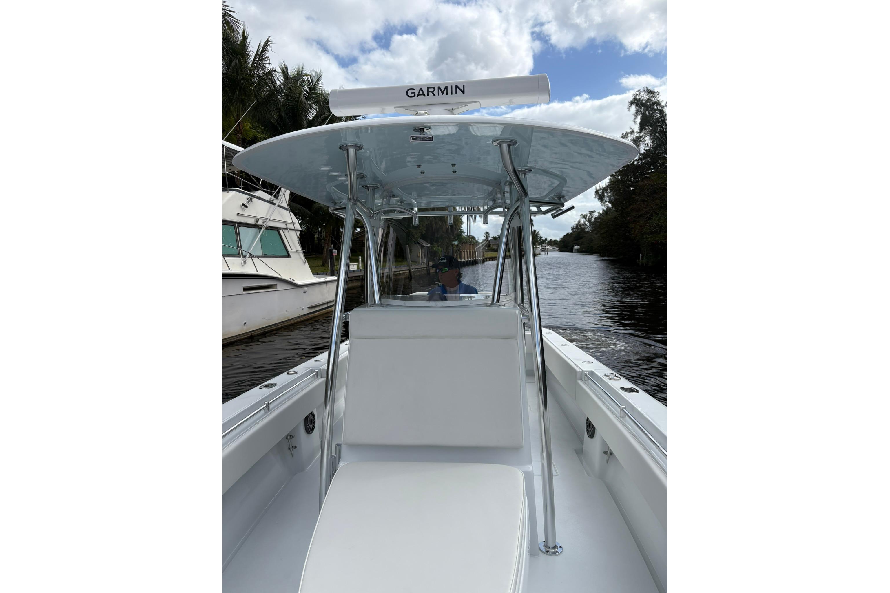 2025 Contender 32 ST boat on a calm waterway, featuring Garmin equipment.