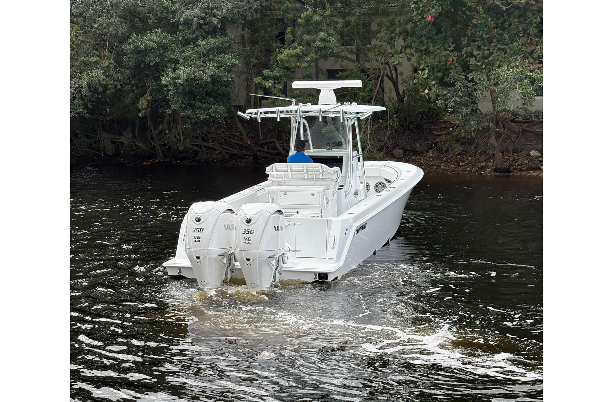 2025 Contender 32 ST boat with dual engines on a calm river.