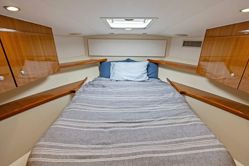 Mahirita Yacht Photos Pics Cozy cabin interior of 2014 Viking 42 Open yacht with bed and wooden cabinets.