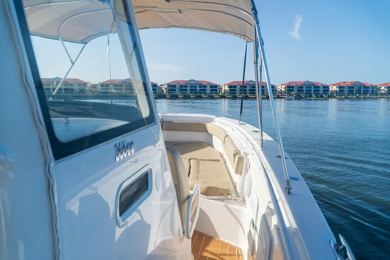 Love Me Tender Yacht Photos Pics 2019 Everglades 355 Center Console boat on calm water with waterfront buildings in the background.