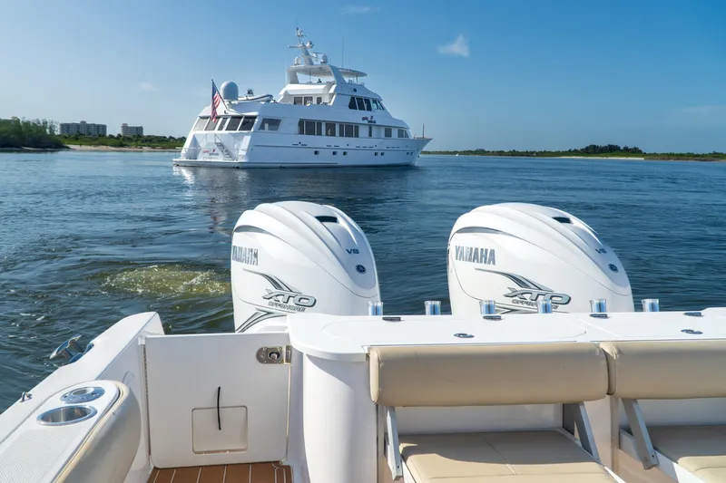 Love Me Tender Yacht Photos Pics 2019 Everglades 355 Center Console with Yamaha engines, cruising near a luxury yacht.