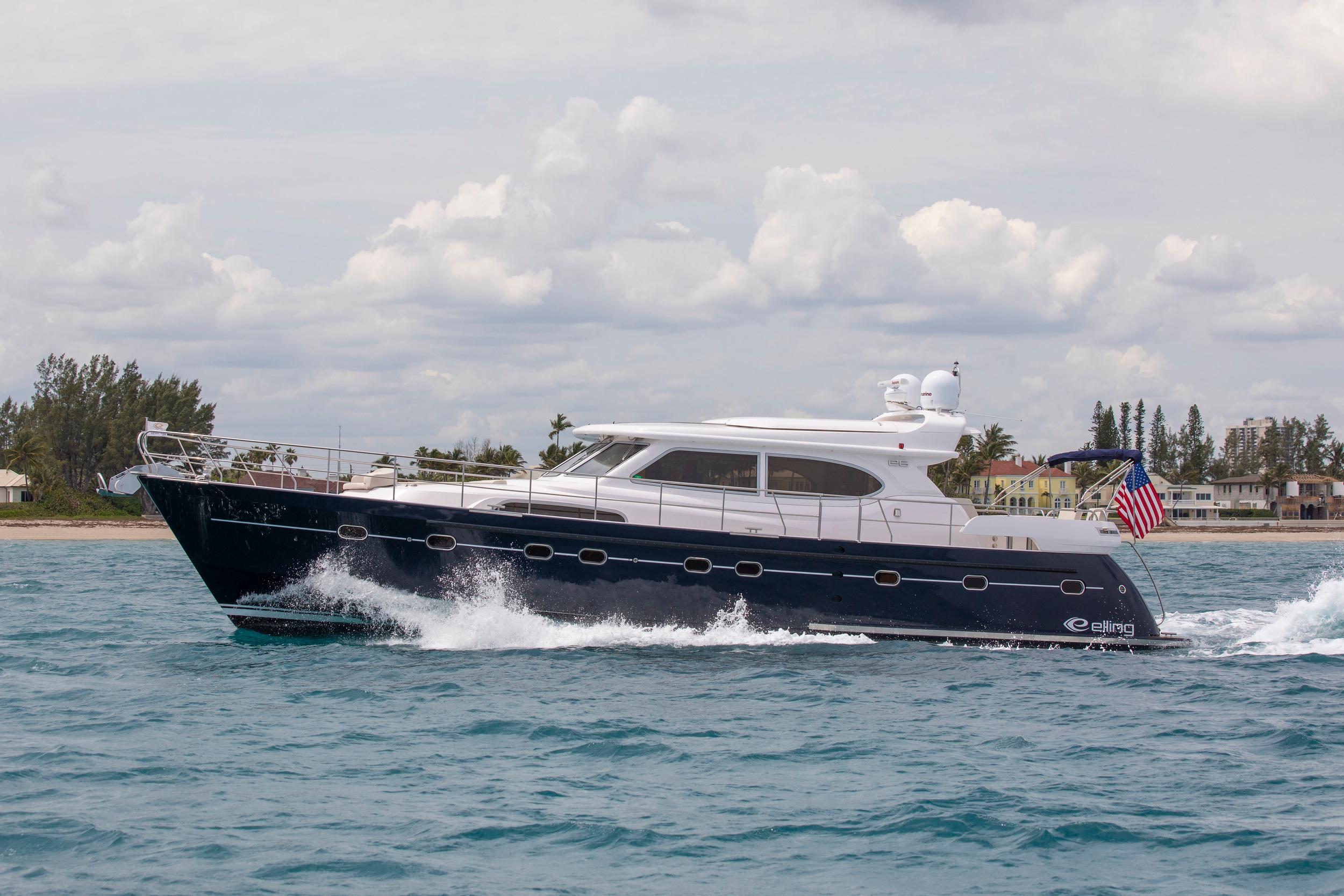 2026 Elling E6 yacht cruising on the ocean near a coastal town.