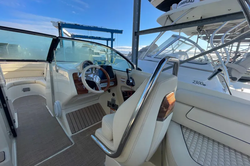  Yacht Photos Pics 2020 Chris-Craft Launch 28 GT interior with steering wheel and seating, docked at marina.