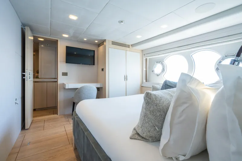 Rocco Yacht Photos Pics Luxurious bedroom on the 2021 Monte Carlo Yachts MCY 96 with modern decor and porthole windows.