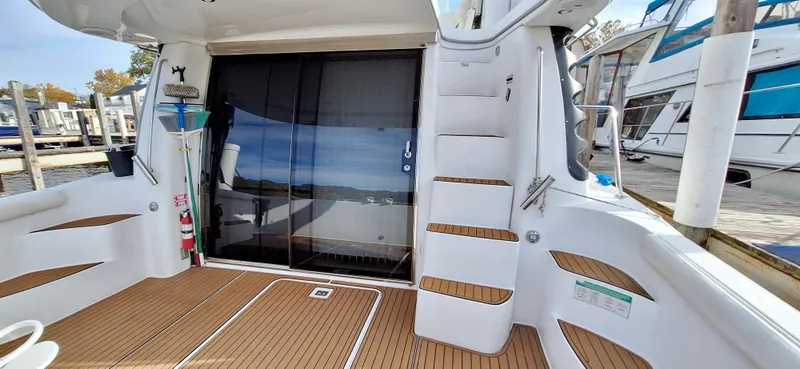 Regina Rae Yacht Photos Pics 1999 Carver 450 Voyager Pilothouse yacht deck with stairs and marina view.