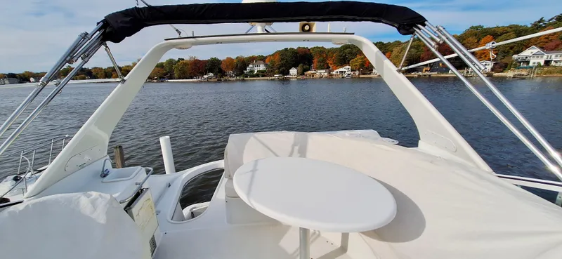 Regina Rae Yacht Photos Pics 1999 Carver 450 Voyager Pilothouse on a scenic lake with autumn foliage.