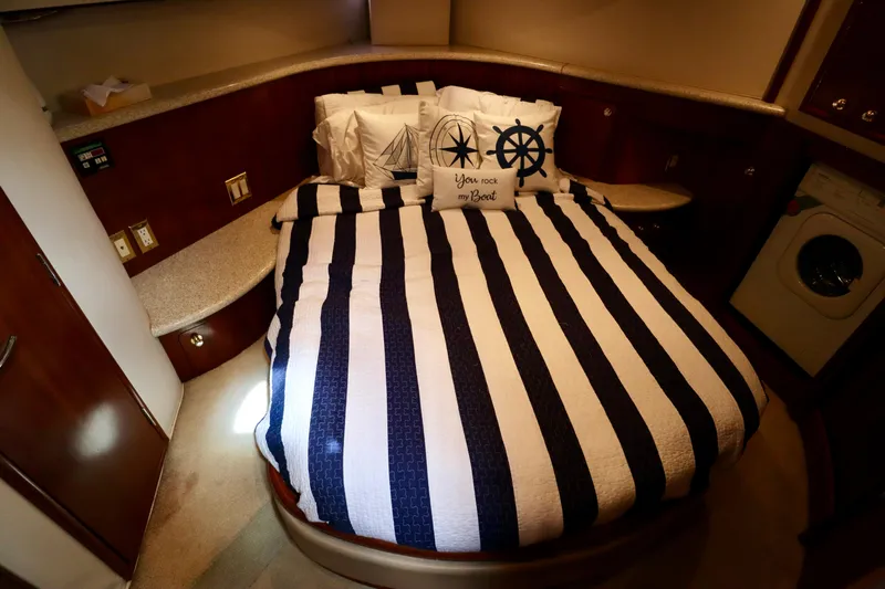 Regina Rae Yacht Photos Pics 1999 Carver 450 Voyager Pilothouse bedroom with striped bedding and nautical-themed pillows.