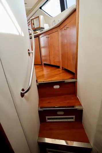 Regina Rae Yacht Photos Pics Staircase inside 1999 Carver 450 Voyager Pilothouse, featuring wooden steps and cabinetry.