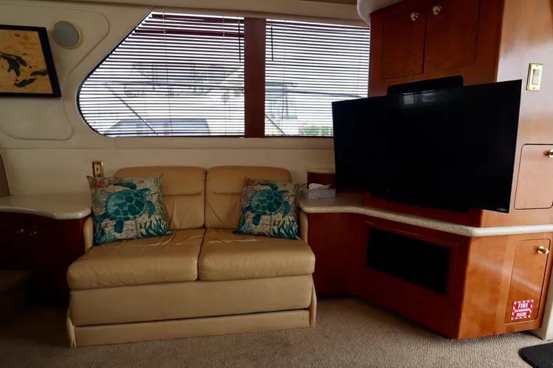 Regina Rae Yacht Photos Pics Interior of 1999 Carver 450 Voyager Pilothouse with sofa, turtle pillows, and TV.