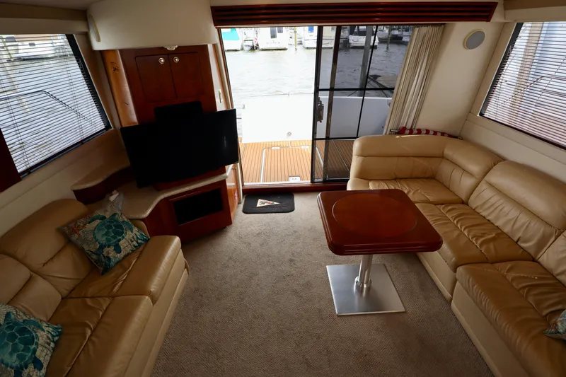 Regina Rae Yacht Photos Pics Luxurious interior of 1999 Carver 450 Voyager Pilothouse with leather seating and wooden table.