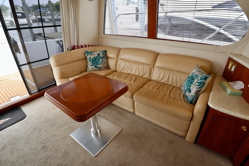 Regina Rae Yacht Photos Pics Luxurious interior of 1999 Carver 450 Voyager Pilothouse with leather sofa and wooden table.