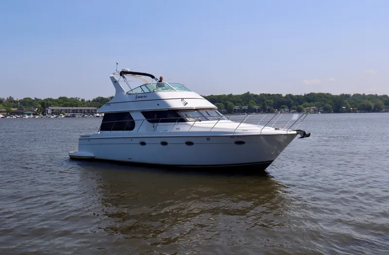 Regina Rae Yacht Photos Pics 1999 Carver 450 Voyager Pilothouse yacht on calm water, clear sky background.
