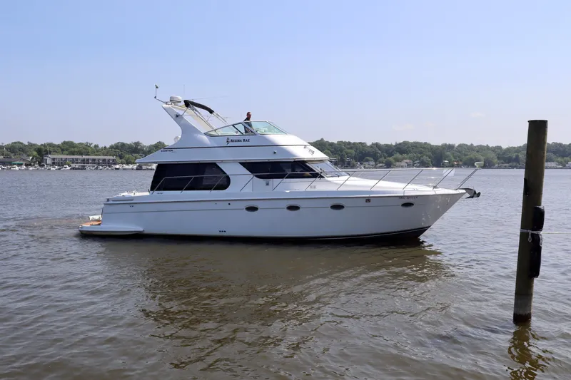 Regina Rae Yacht Photos Pics 1999 Carver 450 Voyager Pilothouse yacht on calm water, side view.