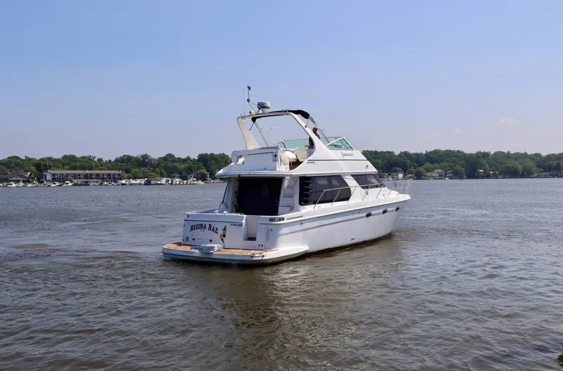 Regina Rae Yacht Photos Pics 1999 Carver 450 Voyager Pilothouse yacht cruising on a calm lake.