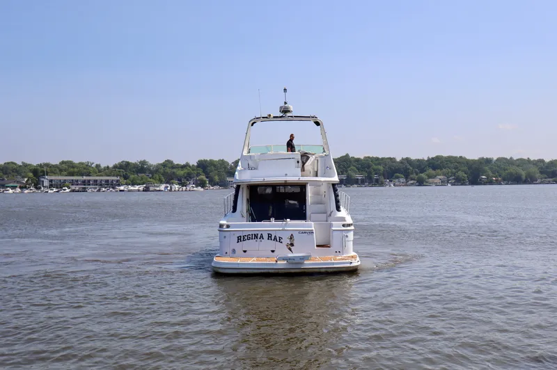 Regina Rae Yacht Photos Pics 1999 Carver 450 Voyager Pilothouse yacht on a calm lake, rear view.