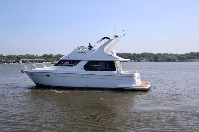 Regina Rae Yacht Photos Pics 1999 Carver 450 Voyager Pilothouse yacht cruising on a calm lake.
