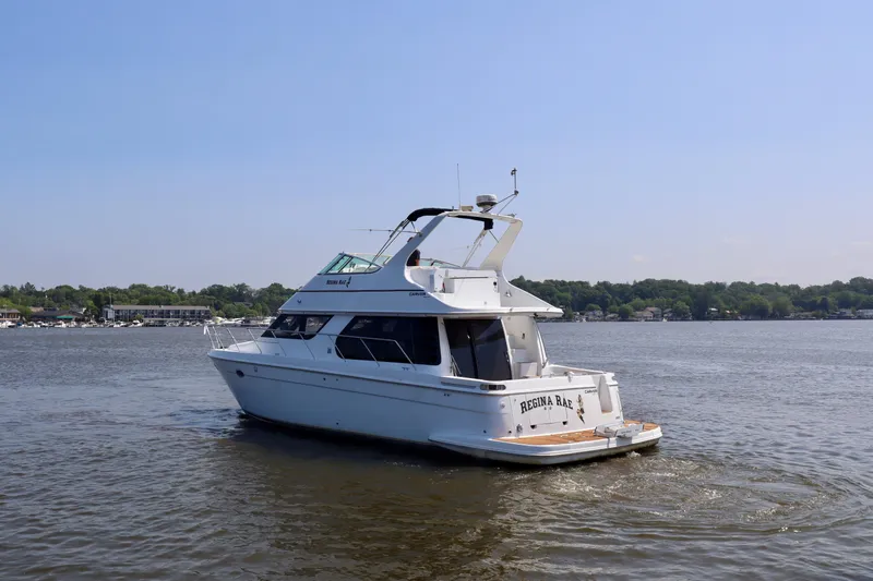Regina Rae Yacht Photos Pics 1999 Carver 450 Voyager Pilothouse yacht cruising on a calm lake.