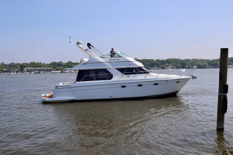 Regina Rae Yacht Photos Pics 1999 Carver 450 Voyager Pilothouse yacht cruising on a calm river.