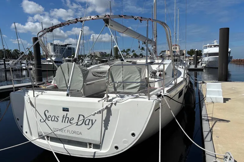  Yacht Photos Pics 2014 Bavaria Vision 46 sailboat docked, named "Seas the Day," in a sunny marina.