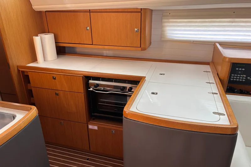  Yacht Photos Pics Modern kitchen in 2014 Bavaria Vision 46 yacht with wooden cabinetry and compact stove.