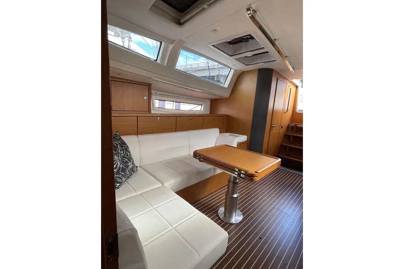  Yacht Photos Pics Interior of 2014 Bavaria Vision 46 yacht with white seating and wooden table.