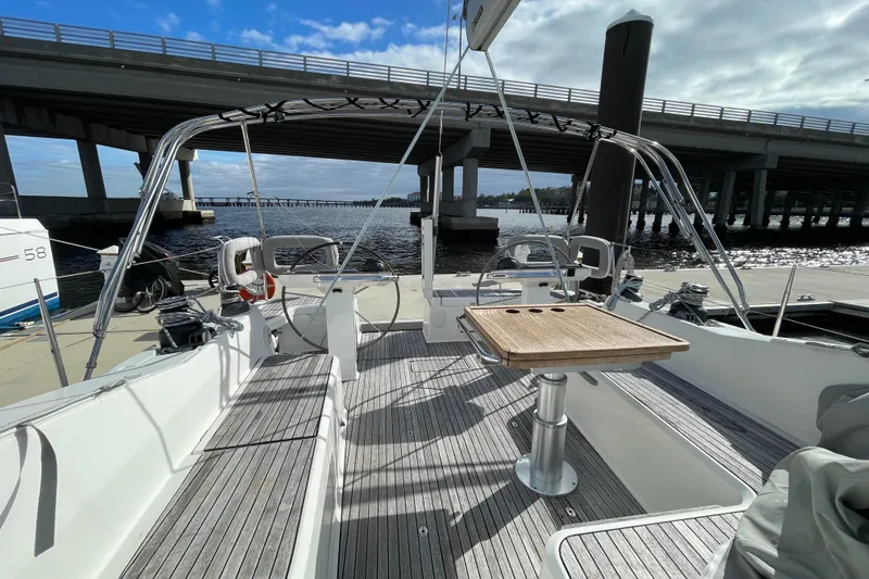  Yacht Photos Pics 2014 Bavaria Vision 46 sailboat cockpit with wooden table, docked under a bridge.