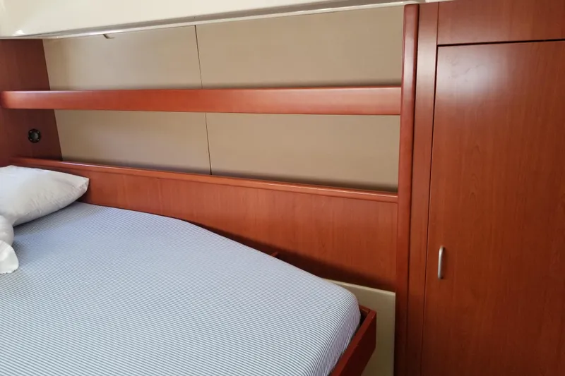 Zumbrota Yacht Photos Pics Interior cabin of 2014 Leopard 48 yacht with wooden paneling and bed.