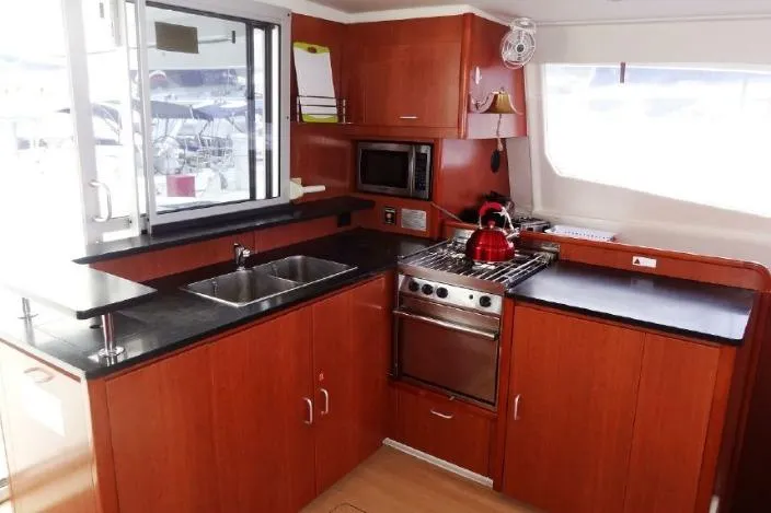 Zumbrota Yacht Photos Pics Modern kitchen interior on 2014 Leopard 48 yacht with wood cabinets and stainless steel appliances.