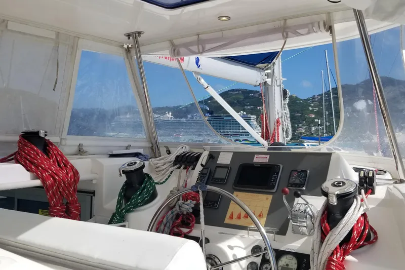 Zumbrota Yacht Photos Pics Interior view of a 2014 Leopard 48 sailboat cockpit with navigation equipment and colorful ropes.