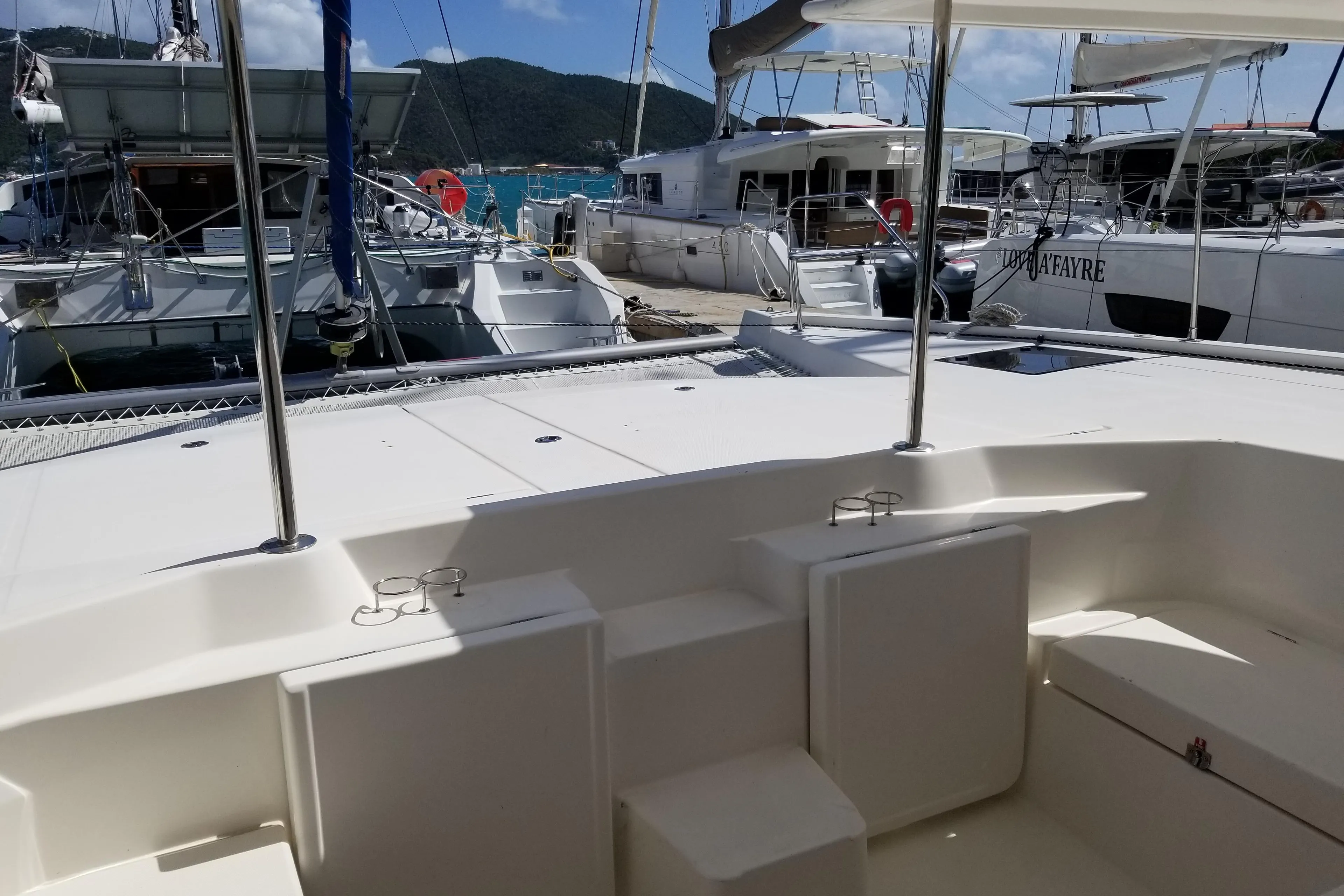 Leopard 48 catamaran docked at marina, showcasing spacious deck and seating area.