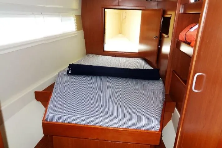 Zumbrota Yacht Photos Pics Cozy cabin interior of 2014 Leopard 48 yacht with striped bedding and wooden furnishings.